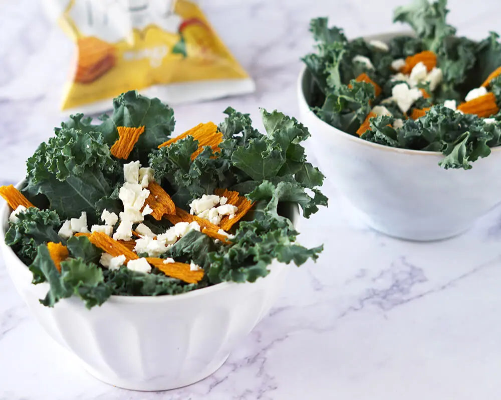Kale salad on a bowl topped with TASU Fruit Chips and cheese